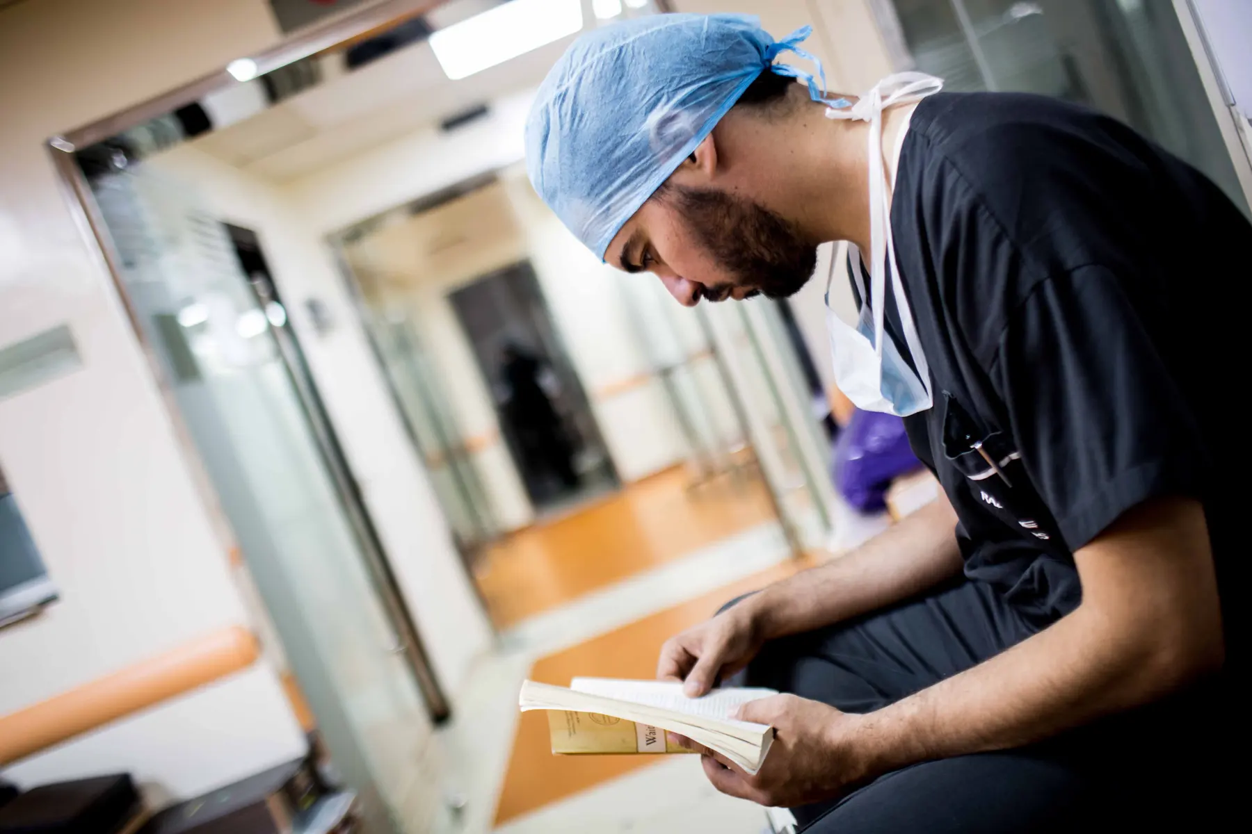 A medical student studying between cases in scrubs